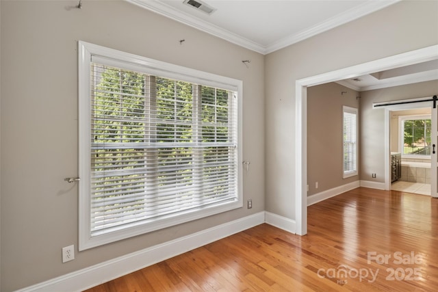 2411 Stoney Run Dr Unit 13, Oakboro, NC 28129 - spare room with a barn door, light wood-style floors, and crown molding