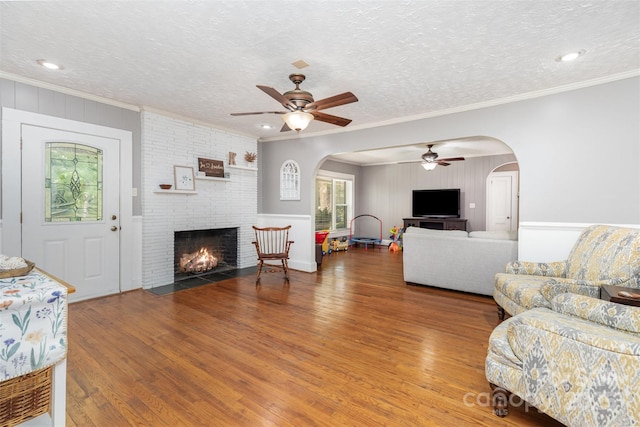 304 W Colonial Dr, Salisbury, NC 28144 - living area featuring a ceiling fan, a fireplace, arched walkways, wood finished floors, and ornamental molding