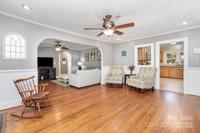 304 W Colonial Dr, Salisbury, NC 28144 - living area with ceiling fan, arched walkways, healthy amount of natural light, light wood-style flooring, and crown molding