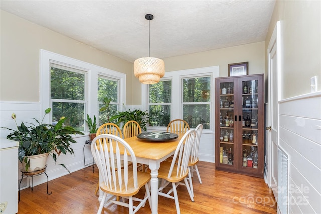 304 W Colonial Dr, Salisbury, NC 28144 - dining area featuring light wood finished floors, a wainscoted wall, and a textured ceiling