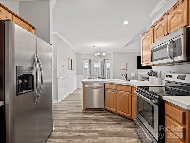 409 Danielle Way, Fort Mill, SC 29715 - kitchen with appliances with stainless steel finishes, a peninsula, ornamental molding, light wood-style flooring, and a chandelier