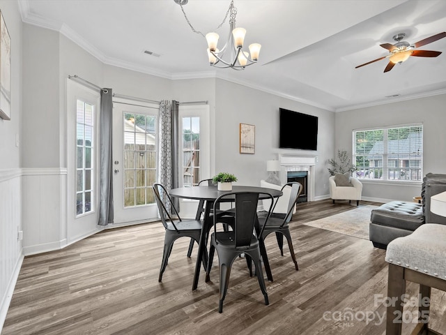 409 Danielle Way, Fort Mill, SC 29715 - dining area featuring wood finished floors, a chandelier, healthy amount of natural light, a fireplace, and ornamental molding