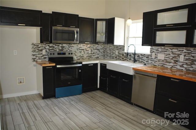 1312 Shenandoah Cir, Rock Hill, SC 29730 - kitchen featuring appliances with stainless steel finishes, dark cabinets, wood counters, decorative backsplash, and light wood-style flooring