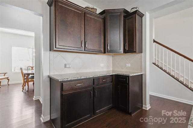 212 Fesperman Cir, Troutman, NC 28166 - kitchen with dark wood-style flooring, light stone countertops, decorative backsplash, and dark brown cabinetry