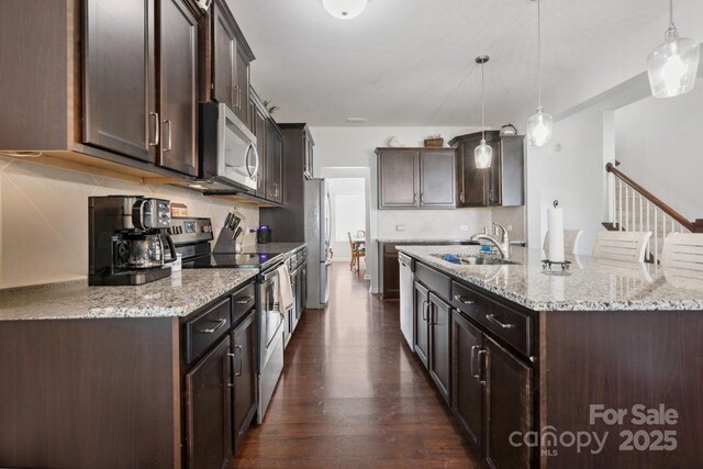 212 Fesperman Cir, Troutman, NC 28166 - kitchen with stainless steel appliances, dark brown cabinetry, dark wood-style floors, and a kitchen island with sink