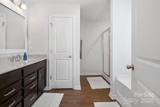 212 Fesperman Cir, Troutman, NC 28166 - full bathroom featuring vanity, wood finished floors, a shower stall, and a garden tub