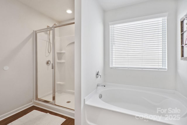 212 Fesperman Cir, Troutman, NC 28166 - bathroom featuring a stall shower, a garden tub, and wood finished floors
