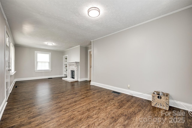 903 Rhode Island Ave, Kannapolis, NC 28083 - unfurnished living room featuring a textured ceiling, dark wood-style floors, a brick fireplace, and ornamental molding