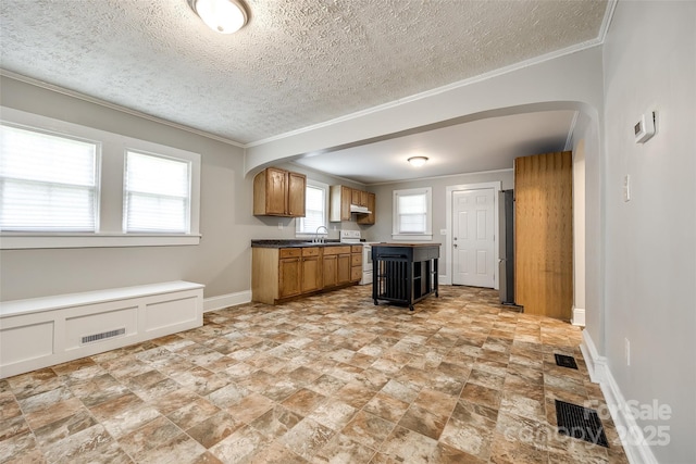903 Rhode Island Ave, Kannapolis, NC 28083 - kitchen with arched walkways, white electric stove, ornamental molding, freestanding refrigerator, and a textured ceiling
