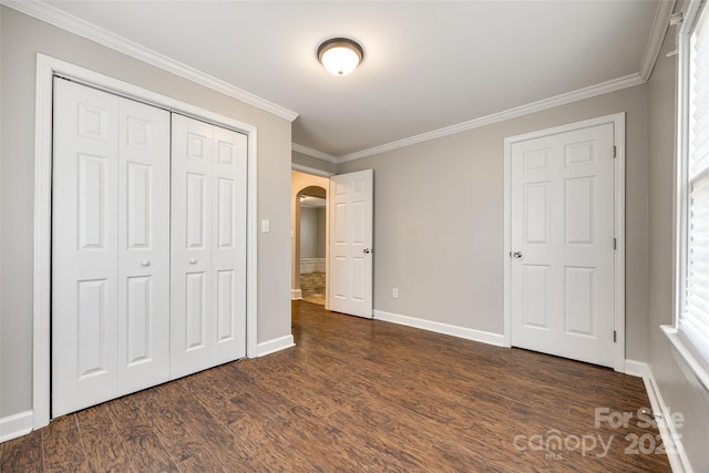903 Rhode Island Ave, Kannapolis, NC 28083 - unfurnished bedroom with arched walkways, dark wood-type flooring, ornamental molding, and a closet