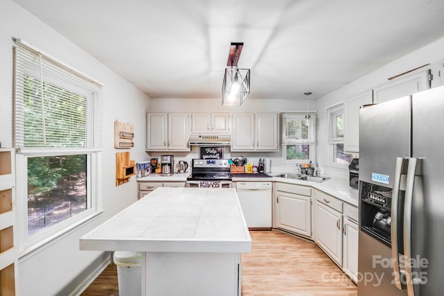 2116 Bon Villa Way, Fort Mill, SC 29708 - kitchen featuring appliances with stainless steel finishes, light wood-style flooring, a kitchen island, under cabinet range hood, and white cabinetry