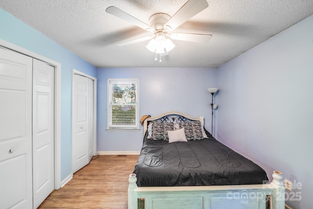 2116 Bon Villa Way, Fort Mill, SC 29708 - bedroom with a textured ceiling, light wood-type flooring, multiple closets, and a ceiling fan