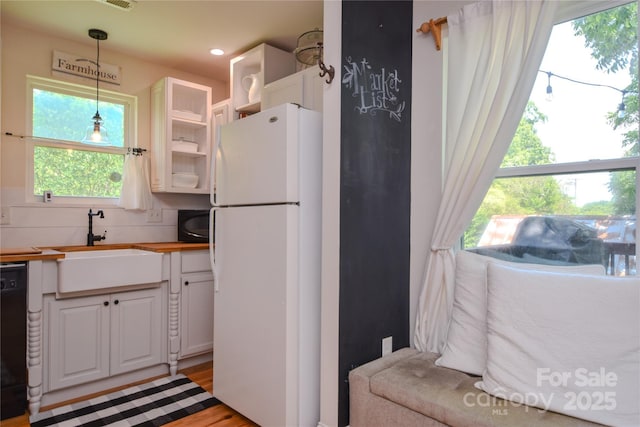 1239 Mac Ln, Stanley, NC 28164 - kitchen with freestanding refrigerator, white cabinetry, hanging light fixtures, wooden counters, and open shelves