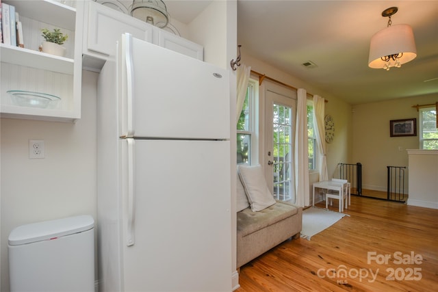 1239 Mac Ln, Stanley, NC 28164 - kitchen with freestanding refrigerator, light wood finished floors, and white cabinetry
