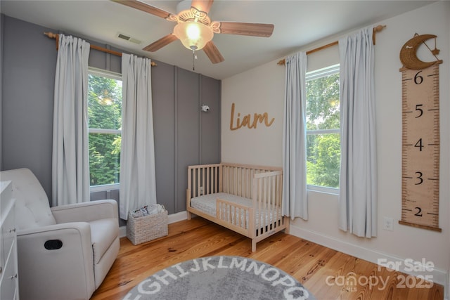1239 Mac Ln, Stanley, NC 28164 - bedroom with multiple windows, wood finished floors, and a crib
