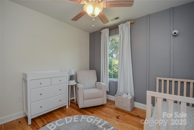 1239 Mac Ln, Stanley, NC 28164 - bedroom featuring wood finished floors, a crib, and a ceiling fan