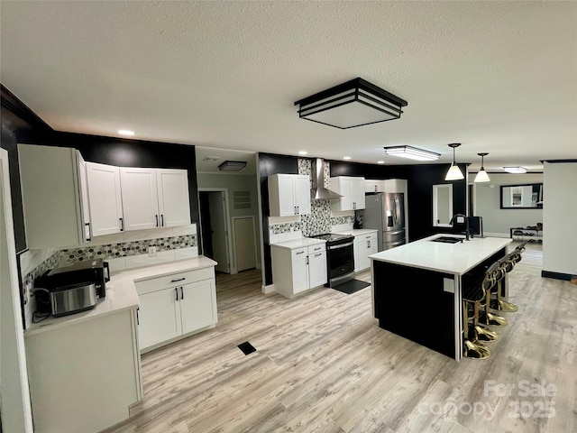 6490 Alta Ctr, Denver, NC 28037 - kitchen featuring electric range, wall chimney range hood, stainless steel fridge, decorative backsplash, and light wood-style floors
