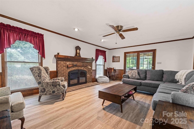 36433 Azalea Cir, New London, NC 28127 - living area with wood finished floors, wainscoting, a ceiling fan, ornamental molding, and a brick fireplace