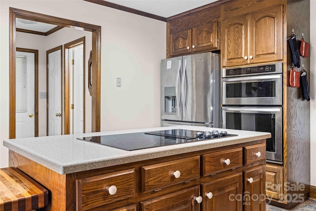 36433 Azalea Cir, New London, NC 28127 - kitchen featuring appliances with stainless steel finishes, crown molding, light countertops, a center island, and brown cabinets