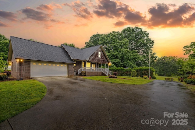 36433 Azalea Cir, New London, NC 28127 - chalet / cabin featuring asphalt driveway, an attached garage, a front yard, brick siding, and covered porch