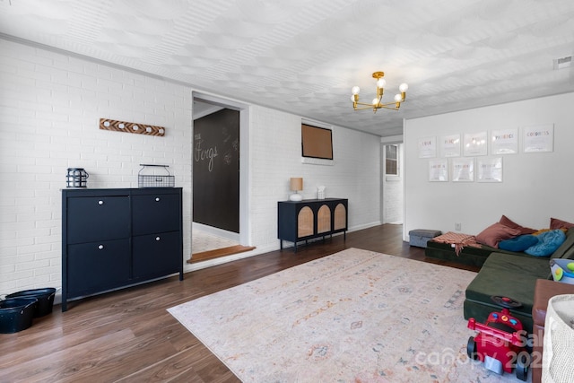 2623 NE 13th St NE, Hickory, NC 28601 - living room with dark wood-style floors, brick wall, and a chandelier