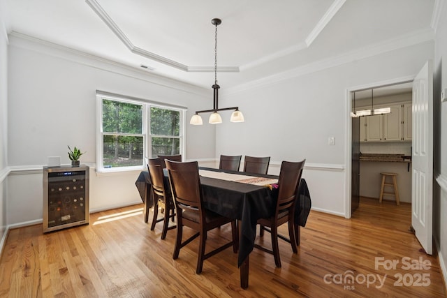 4716 Heatherton Pl, Charlotte, NC 28270 - dining space featuring beverage cooler, light wood-style flooring, a raised ceiling, and ornamental molding
