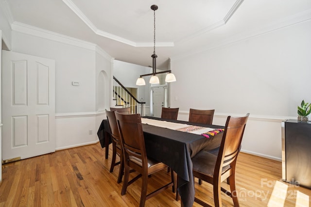 4716 Heatherton Pl, Charlotte, NC 28270 - dining space featuring light wood-style floors, stairs, a raised ceiling, ornamental molding, and arched walkways