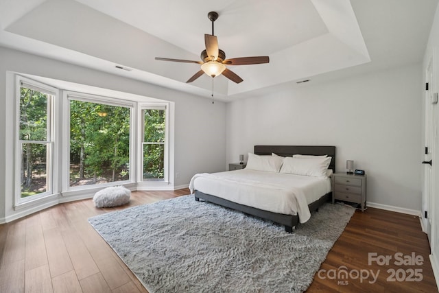 4716 Heatherton Pl, Charlotte, NC 28270 - bedroom featuring a raised ceiling, wood finished floors, and a ceiling fan