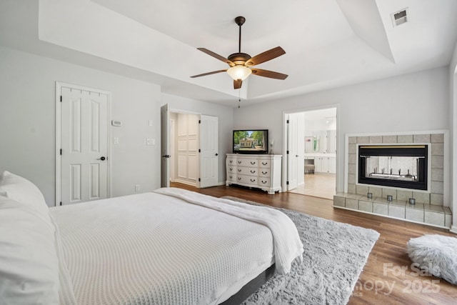 4716 Heatherton Pl, Charlotte, NC 28270 - bedroom with a raised ceiling, wood finished floors, a tile fireplace, and a ceiling fan
