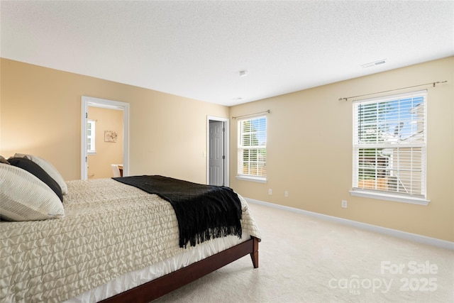 7616 Shiny Meadow Ln, Charlotte, NC 28215 - bedroom with light colored carpet, ensuite bathroom, and a textured ceiling