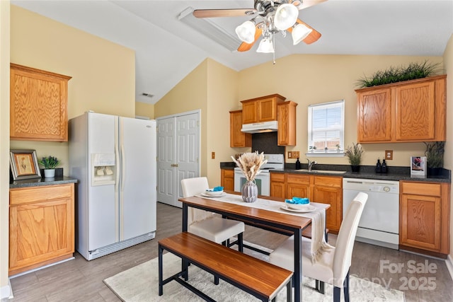 7616 Shiny Meadow Ln, Charlotte, NC 28215 - kitchen featuring white appliances, under cabinet range hood, ceiling fan, vaulted ceiling, and dark countertops