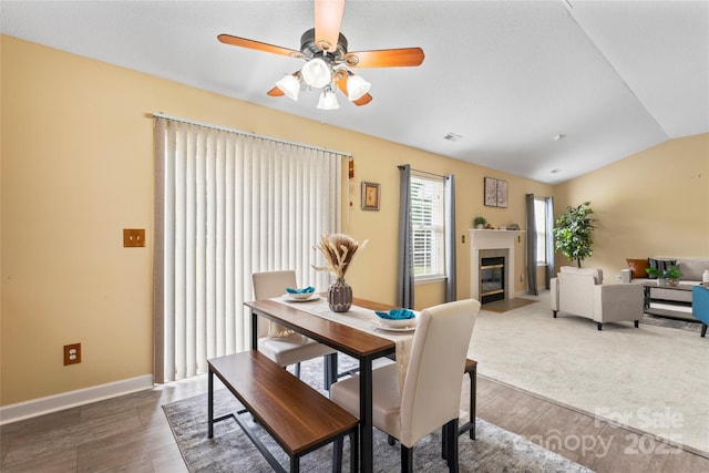 7616 Shiny Meadow Ln, Charlotte, NC 28215 - dining space with dark wood-style flooring, vaulted ceiling, ceiling fan, and a fireplace with flush hearth