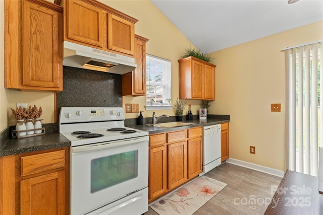 7616 Shiny Meadow Ln, Charlotte, NC 28215 - kitchen featuring white appliances, under cabinet range hood, dark countertops, vaulted ceiling, and light wood-style floors