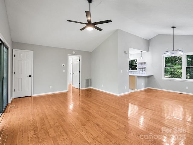 210 Fernwood Dr, Hendersonville, NC 28791 - unfurnished living room with vaulted ceiling, a ceiling fan, and light wood-style floors