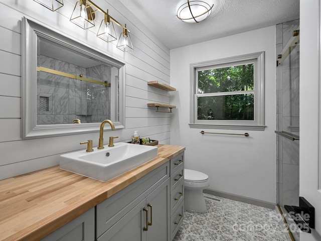 210 Fernwood Dr, Hendersonville, NC 28791 - full bath featuring vanity, a stall shower, wooden walls, and a textured ceiling
