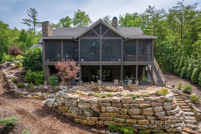 2101 October Dr Unit 150, Nebo, NC 28761 - rear view of house featuring a sunroom, a chimney, a patio area, and an outdoor fire pit
