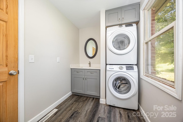 164 Dogtrot Rd, Mocksville, NC 27028 - laundry room featuring stacked washer and clothes dryer, cabinet space, dark wood finished floors, and healthy amount of natural light