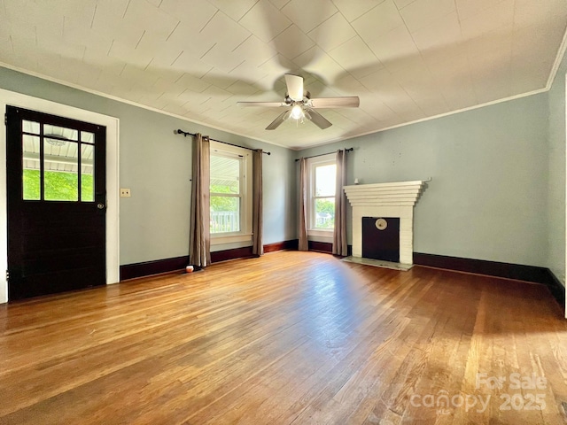 67 N Highland Ave, Granite Falls, NC 28630 - unfurnished living room with crown molding, wood-type flooring, a brick fireplace, and ceiling fan