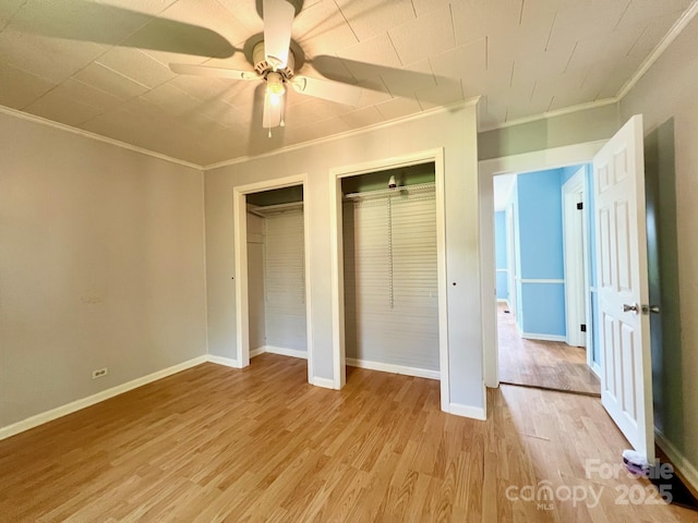 67 N Highland Ave, Granite Falls, NC 28630 - unfurnished bedroom featuring multiple closets, crown molding, light wood-style floors, and ceiling fan