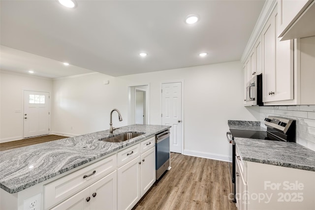 3248 Ferguson Long Rd, York, SC 29745 - kitchen with stainless steel appliances, light wood-style floors, white cabinets, backsplash, and crown molding