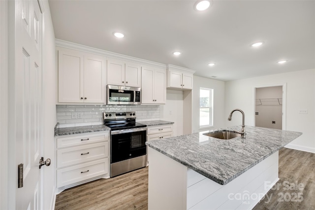 3248 Ferguson Long Rd, York, SC 29745 - kitchen featuring stainless steel appliances, light wood finished floors, white cabinetry, decorative backsplash, and light stone counters