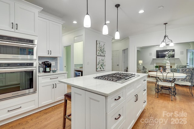 5051 Carillon Way, Charlotte, NC 28270 - kitchen featuring appliances with stainless steel finishes, ornamental molding, white cabinetry, light wood-style floors, and pendant lighting