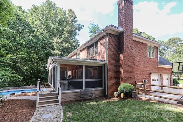 5051 Carillon Way, Charlotte, NC 28270 - back of property featuring a sunroom, brick siding, a chimney, an attached garage, and an outdoor pool