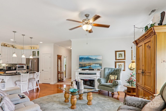 8 Amos Ct, Maggie Valley, NC 28751 - living area with ornamental molding, ceiling fan, light wood finished floors, a high end fireplace, and recessed lighting