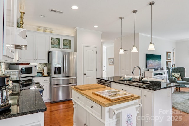 8 Amos Ct, Maggie Valley, NC 28751 - kitchen with appliances with stainless steel finishes, an island with sink, ornamental molding, open floor plan, and wood finished floors