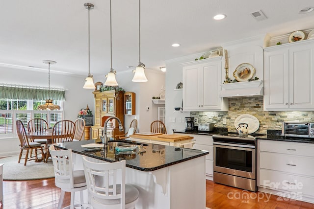 8 Amos Ct, Maggie Valley, NC 28751 - kitchen with electric range, ornamental molding, decorative backsplash, white cabinetry, and a kitchen island with sink