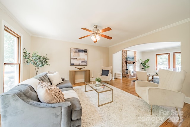 6412 Boykin Spaniel Rd, Charlotte, NC 28277 - living area with arched walkways, wood finished floors, crown molding, a brick fireplace, and ceiling fan