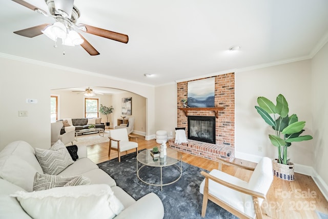 6412 Boykin Spaniel Rd, Charlotte, NC 28277 - living area featuring ornamental molding, wood finished floors, arched walkways, a ceiling fan, and a fireplace