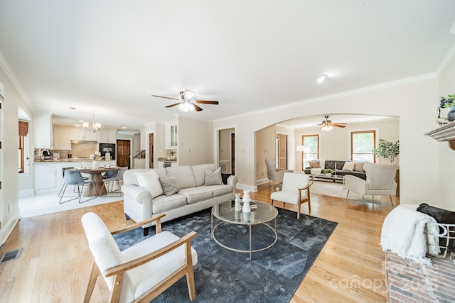 6412 Boykin Spaniel Rd, Charlotte, NC 28277 - living area featuring a ceiling fan, ornamental molding, light wood-style floors, and arched walkways