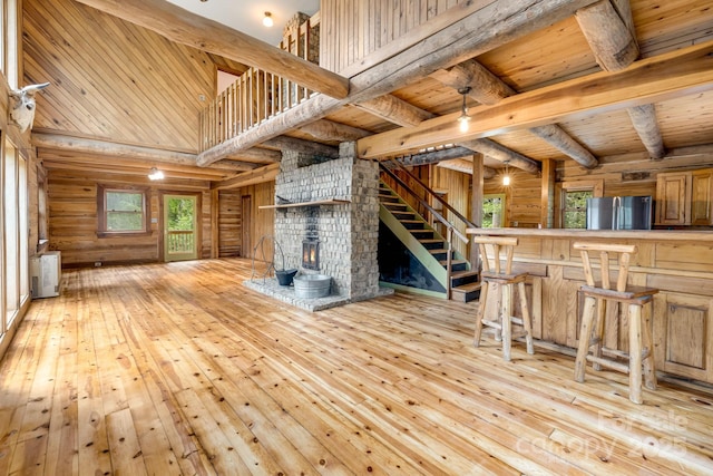 465 Youngs Gap Rd, Fletcher, NC 28732 - unfurnished living room featuring a wooden ceiling with exposed beams, light wood finished floors, plenty of natural light, a towering ceiling, and stairway